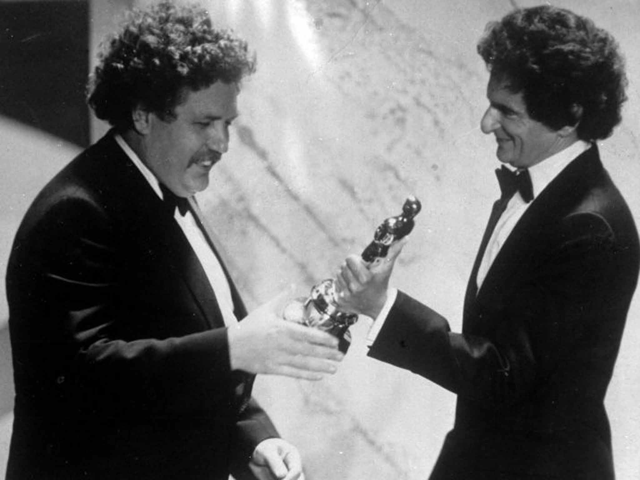 Welland accepts his Oscar for Best Original Screenplay from the novelist Jerzy Kosinski in 1982