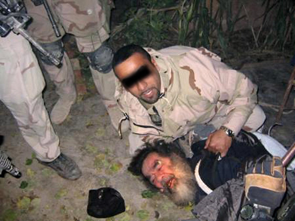 Saddam Hussein being dragged out of his hiding following his capture by US troops in December 2003