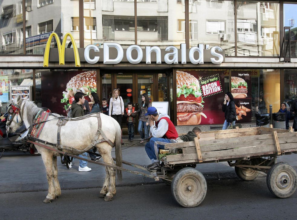 A man waits with a horse and cart outside McDonald's in Skopje, Macedonia