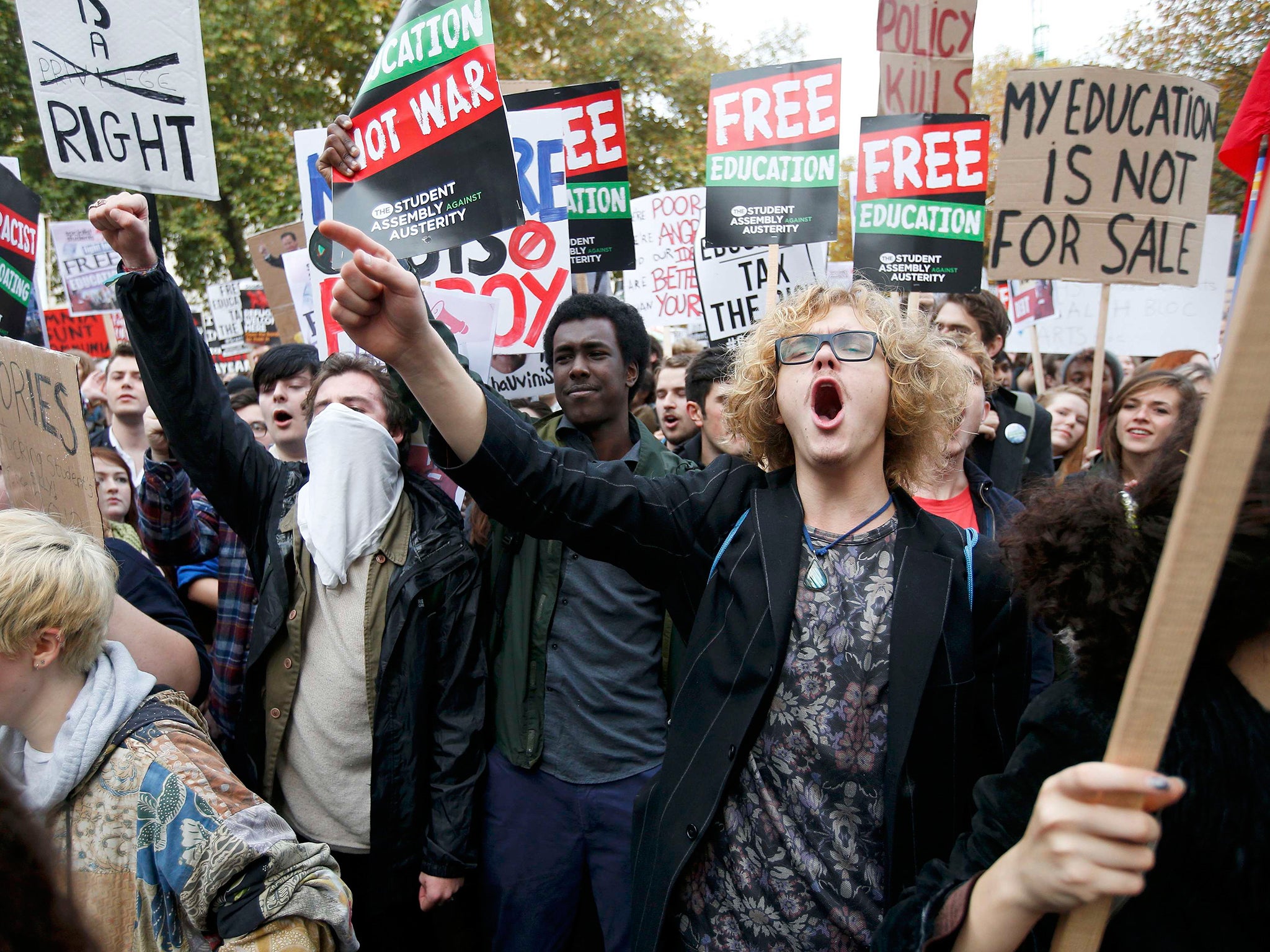 Students shout slogans and hold banners during a demonstration to protest against cuts to grants, in London