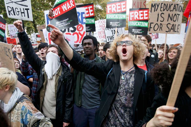 Students shout slogans and hold banners during a demonstration to protest against cuts to grants, in London