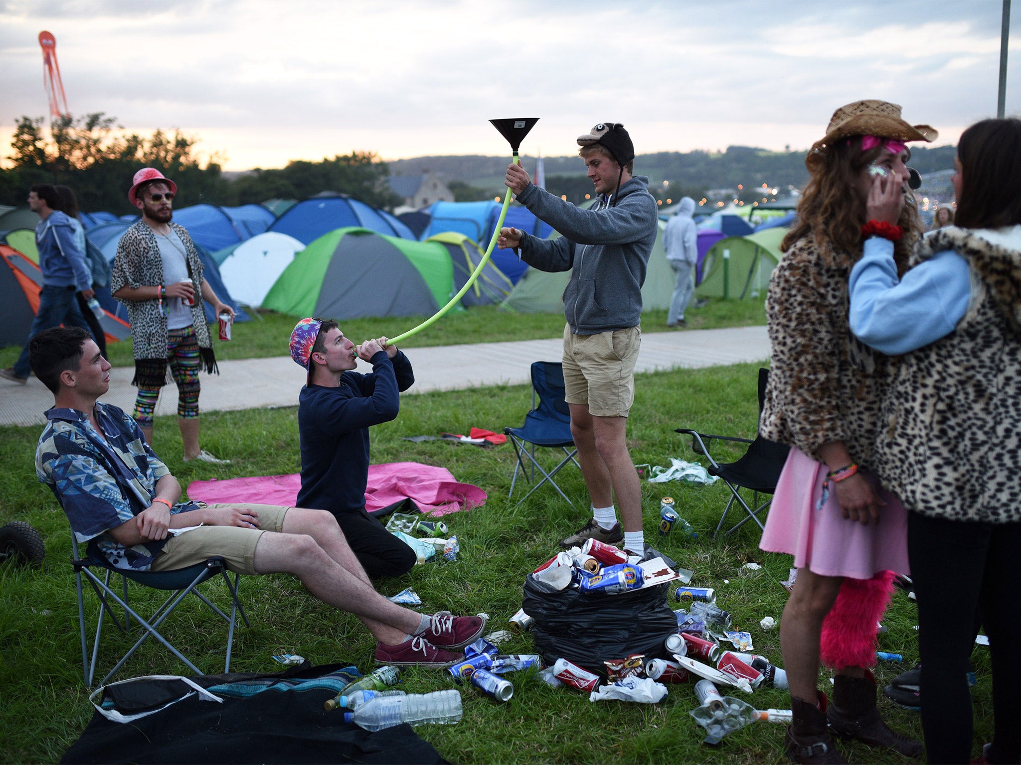 Festival attendees enjoy a drink at Glastonbury Festival (Getty)