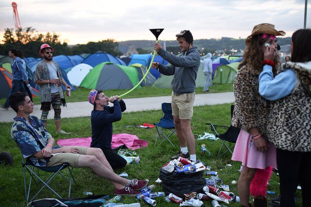 Festival attendees enjoy a drink at Glastonbury Festival (Getty)