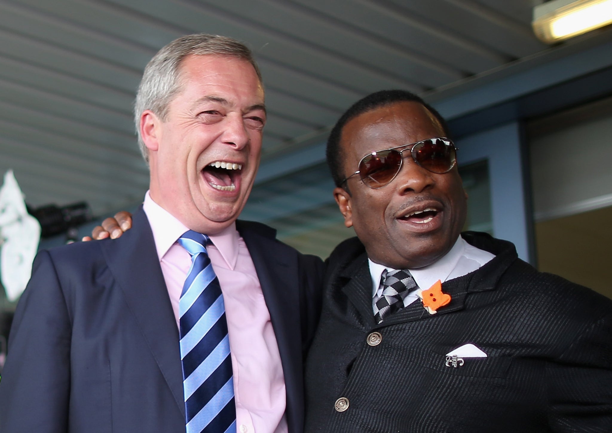 Nigel Farage poses for a photo with the UKIP delegate Winston McKenzie