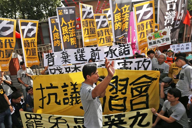Protesters march towards the presidential office in Taipei yesterday, waving banners and denouncing President Ma Ying-jeou’s meeting with China’s President Xi Jinping in Singapore this weekend
