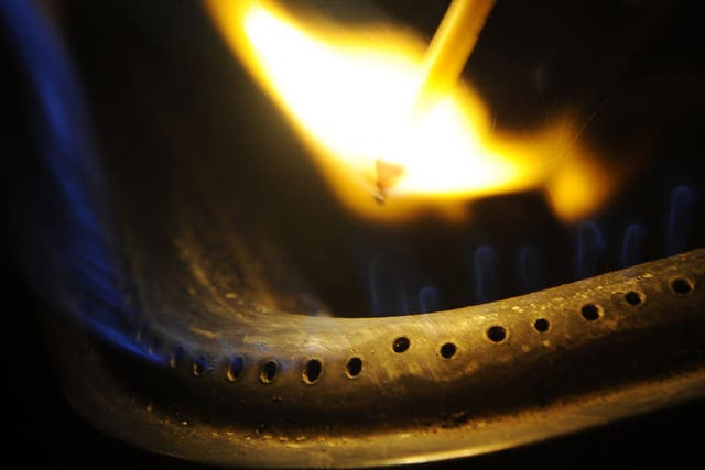 A man lighting a gas stove with a match