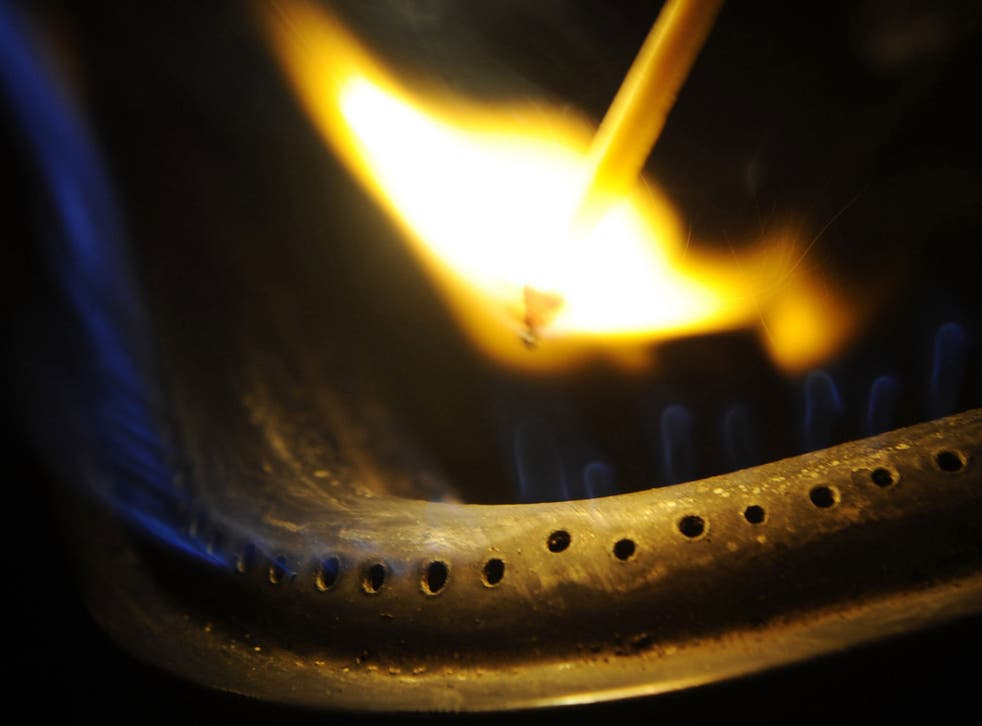 A man lighting a gas stove with a match