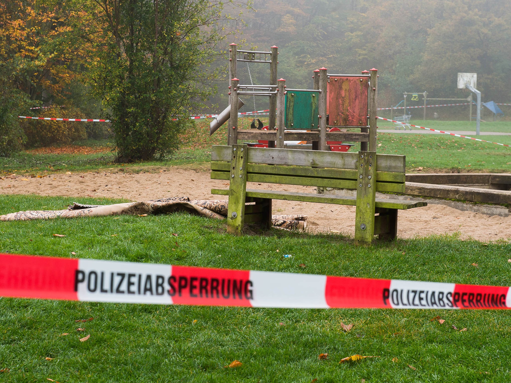 Police tape cordons off the playground bench where the woman burst into flames, in Flensburg, Germany