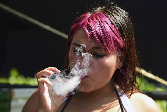 A woman smokes marijuana during a rally in front of the Supreme Court of Justice in Mexico City