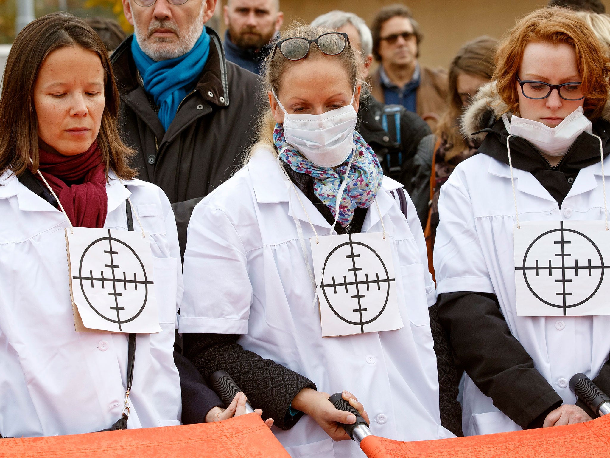 MSF staff wear targets on their chests during a protest in Geneva, one month on from the air strike