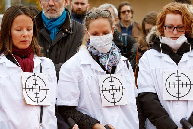 MSF staff wear targets on their chests during a protest in Geneva, one month on from the air strike