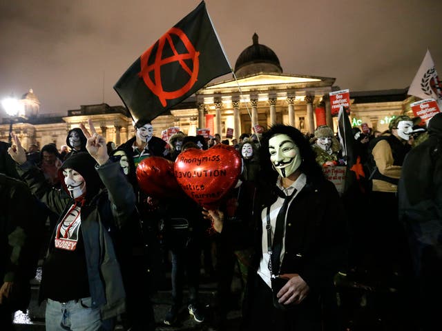 Masked protesters gather in Trafalgar Square