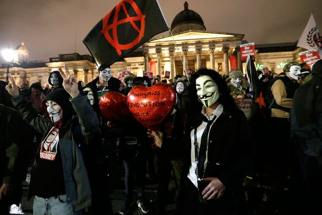 Masked protesters gather in Trafalgar Square