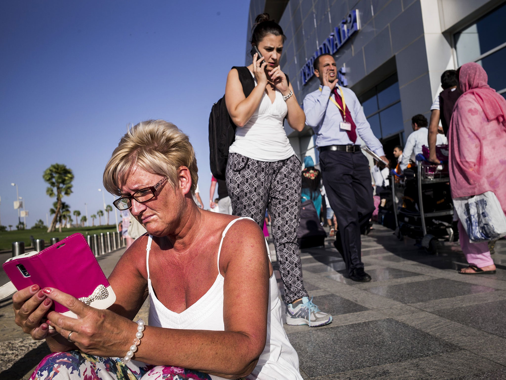 A tourist waits outside the airport at Sharm el-Sheikh, one of around 20,000 Britons who were still stranded in Egypt