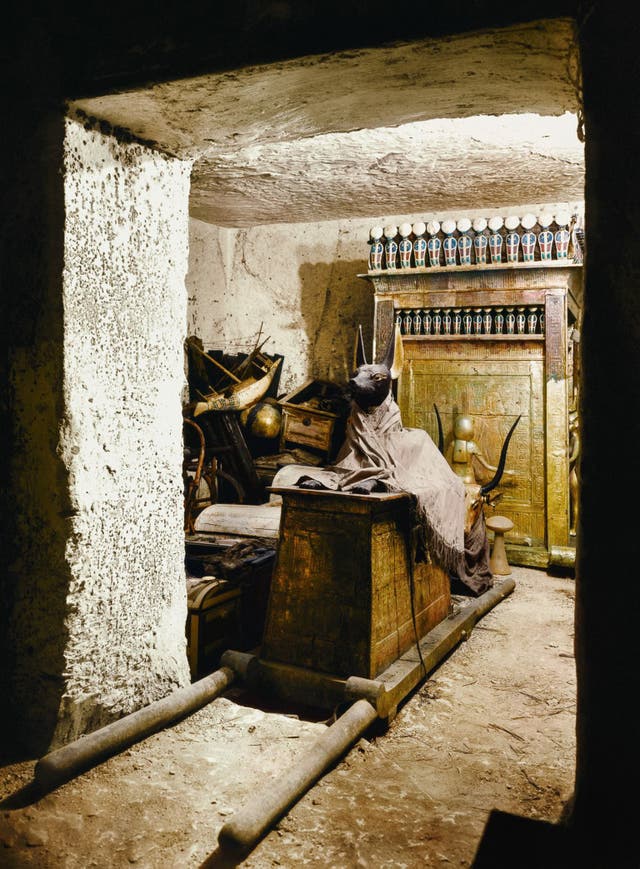 A statue of Anubis on a shrine with pallbearers' poles in the treasury of the tomb, ca.1923. Image courtesy of Griffith Institute, University of Oxford, colourised by Dynamichrome