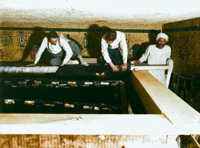 Carter, Mace and an Egyptian worker carefully roll up the linen pall covering the second shrine, 30th October 1923. Image courtesy of Griffith Institute, University of Oxford, colourised by Dynamichrome