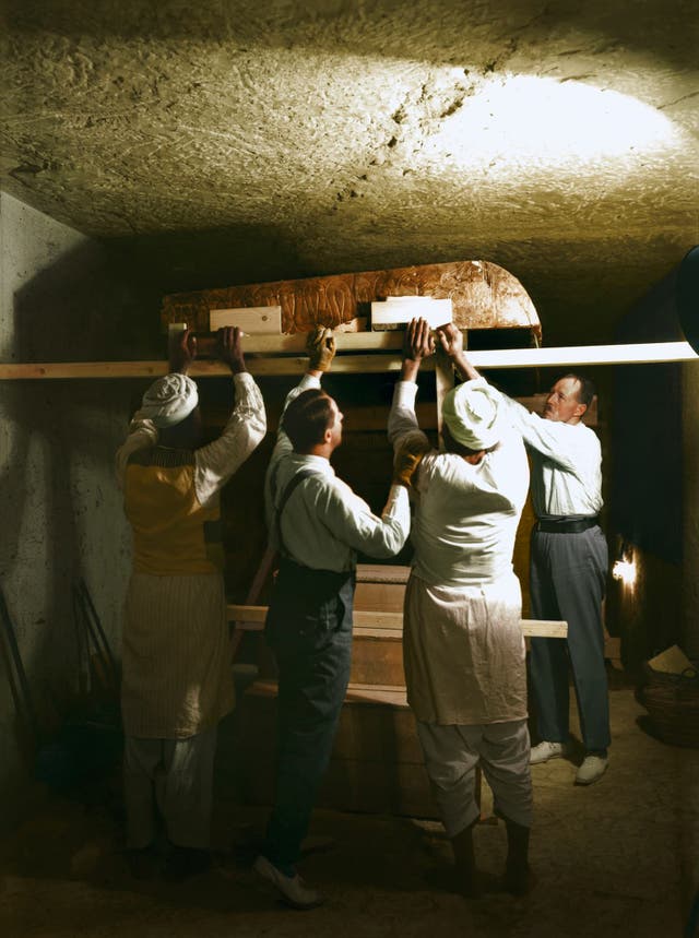 Carter, Callender and two Egyptian workers carefully dismantle one of the golden shrines within the burial chamber, December 1923. Image courtesy of Griffith Institute, University of Oxford, colourised by Dynamichrome