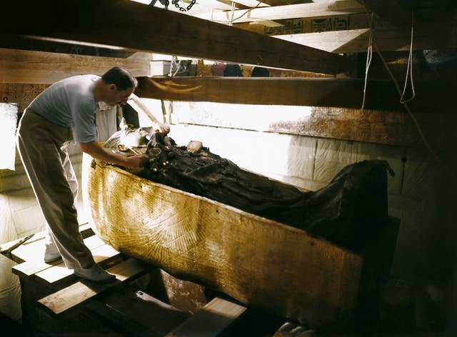 Carter examines Tutankhamun's sarcophagus, October 1925. Image courtesy of Griffith Institute, University of Oxford, colourised by Dynamichrome