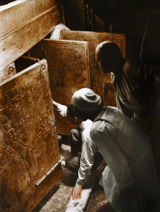 Howard Carter, Arthur Callender and an Egyptian worker open the doors of the innermost shrine and get their first look at Tutankhamun's sarcophagus, 4th January 1924. Image courtesy of Griffith Institute, University of Oxford, colourised by Dynamichrome