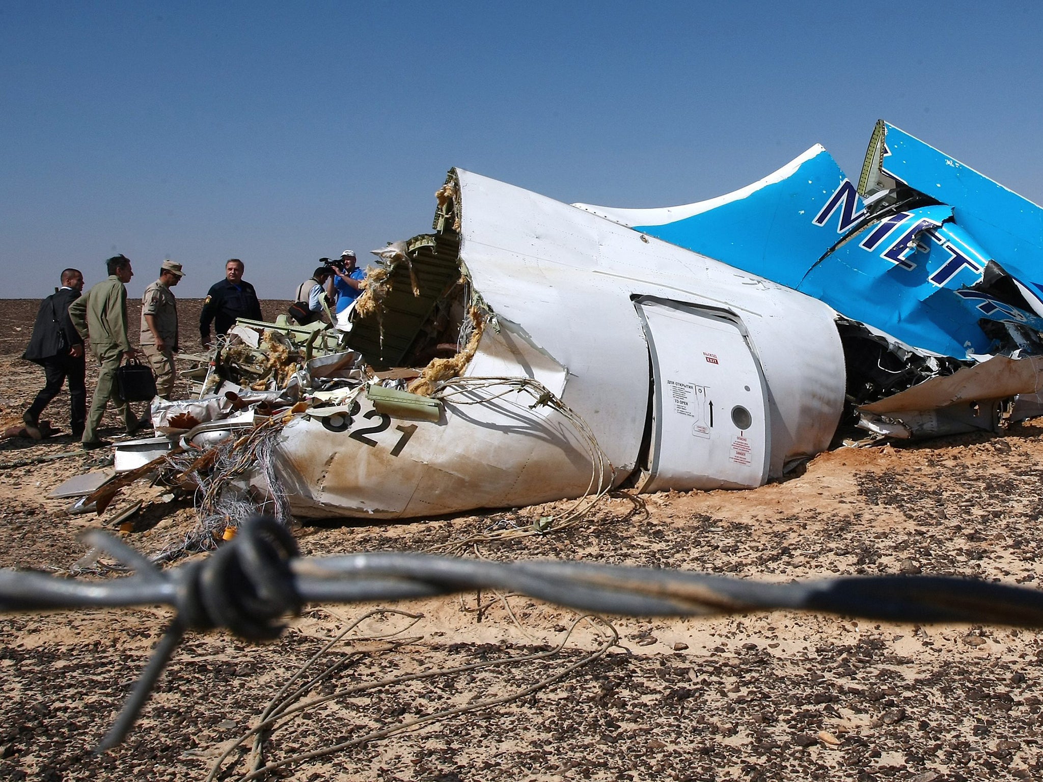 Russian Emergency Situations Minister Vladimir Puchkov (4-L) and unidentified officials near a piece of wreckage of Russian MetroJet Airbus A321 at the site of the crash in Sinai, Egypt