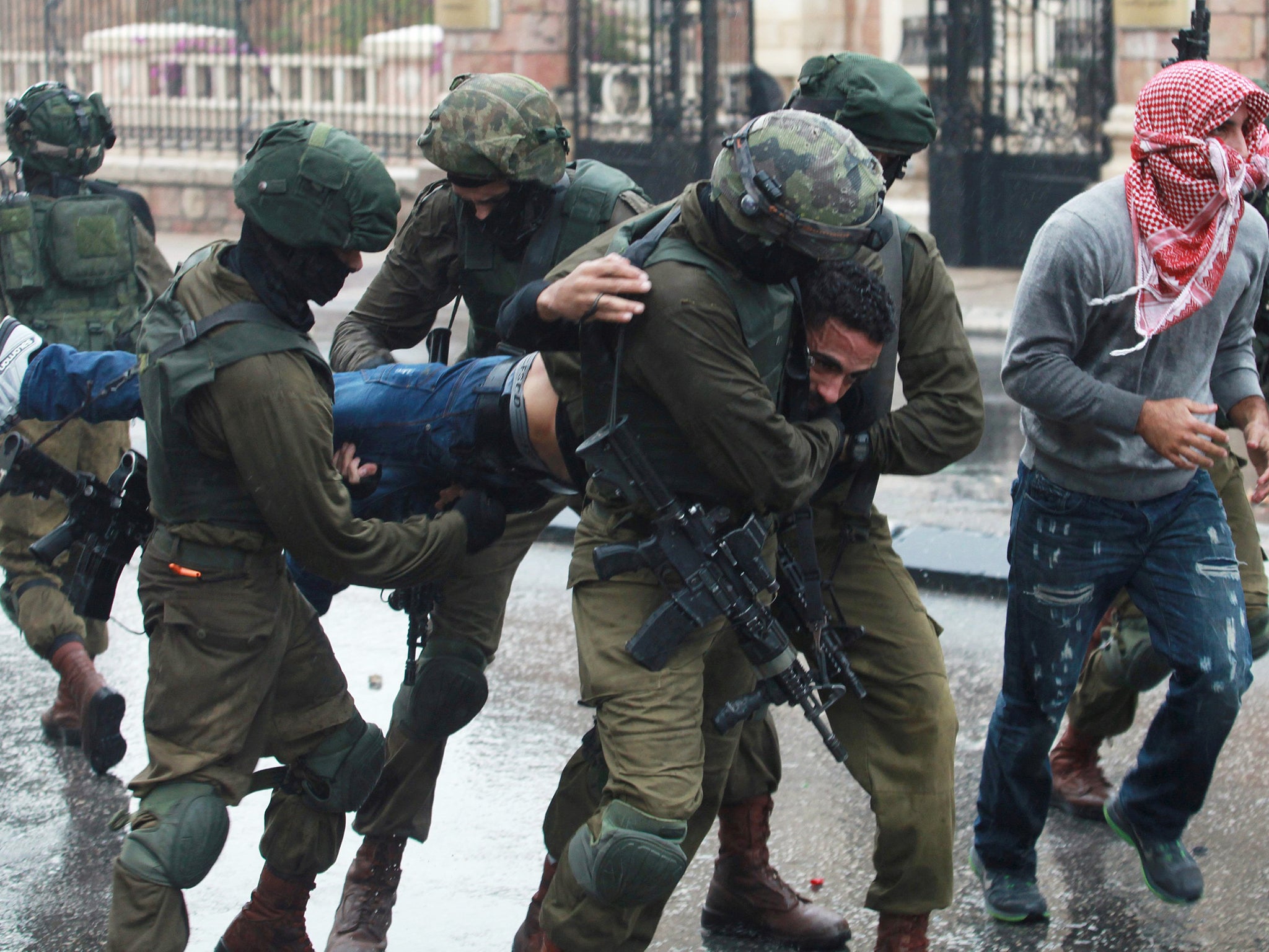 Israeli soldiers and undercover security personnel detain a Palestinian protester during clashes in the West Bank city of Bethlehem