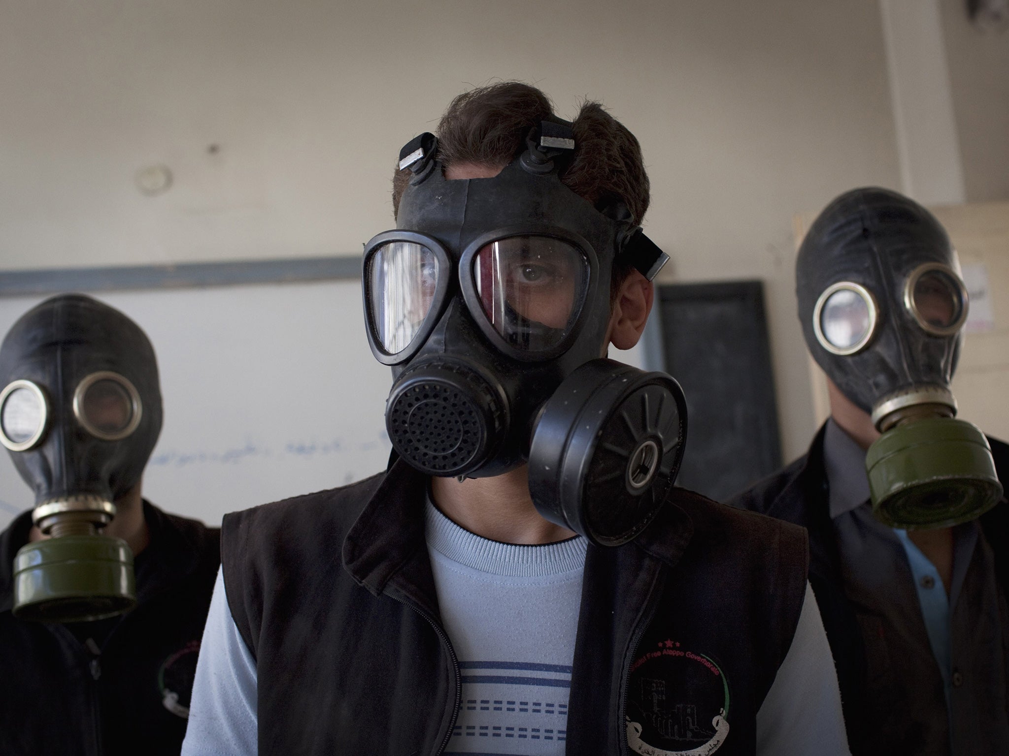Volunteers wear gas masks in Aleppo during a class on how to respond to chemical attacks