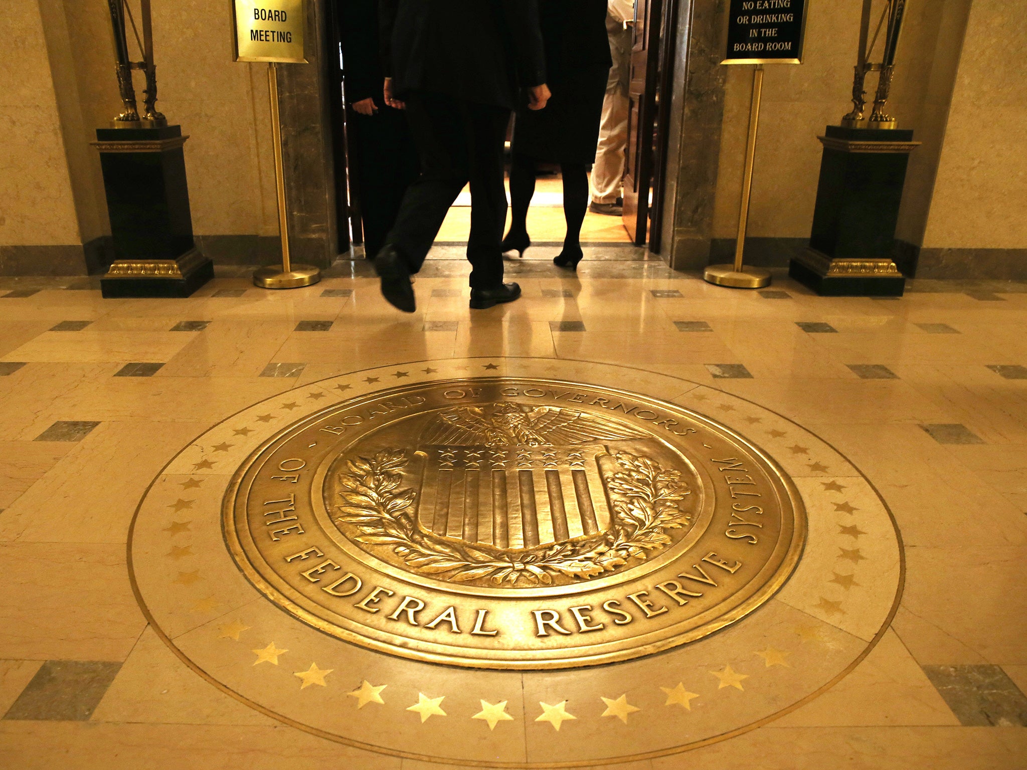 People walk into a meeting of the Board of Governors at the Federal Reserve, October 24, 2013