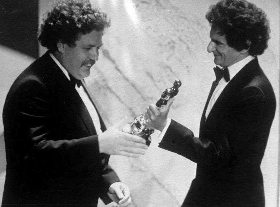 British actor and writer Colin Welland, left, accepts an Oscar for the best screenplay for Chariots of Fire in 1982