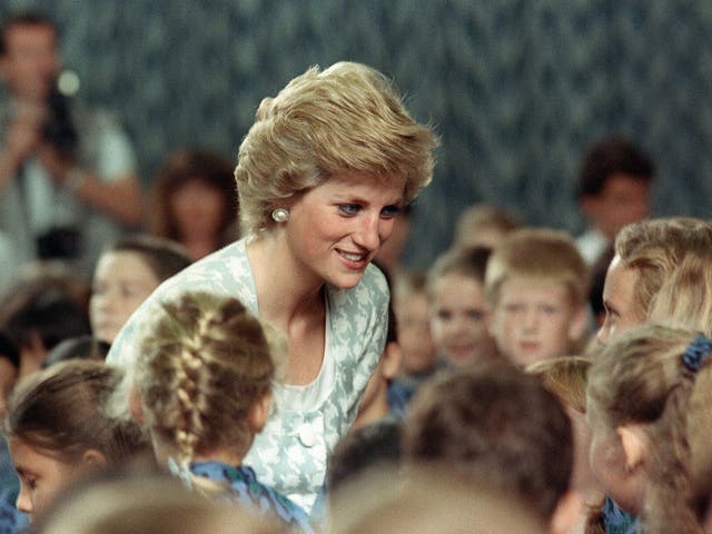 Diana, Princess of Wales listening to children during her visit to the British international school