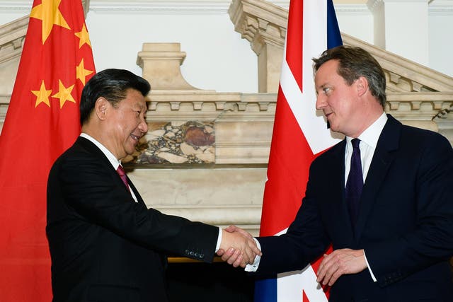 Chinese President Xi Jinping shakes the hand of David Cameron