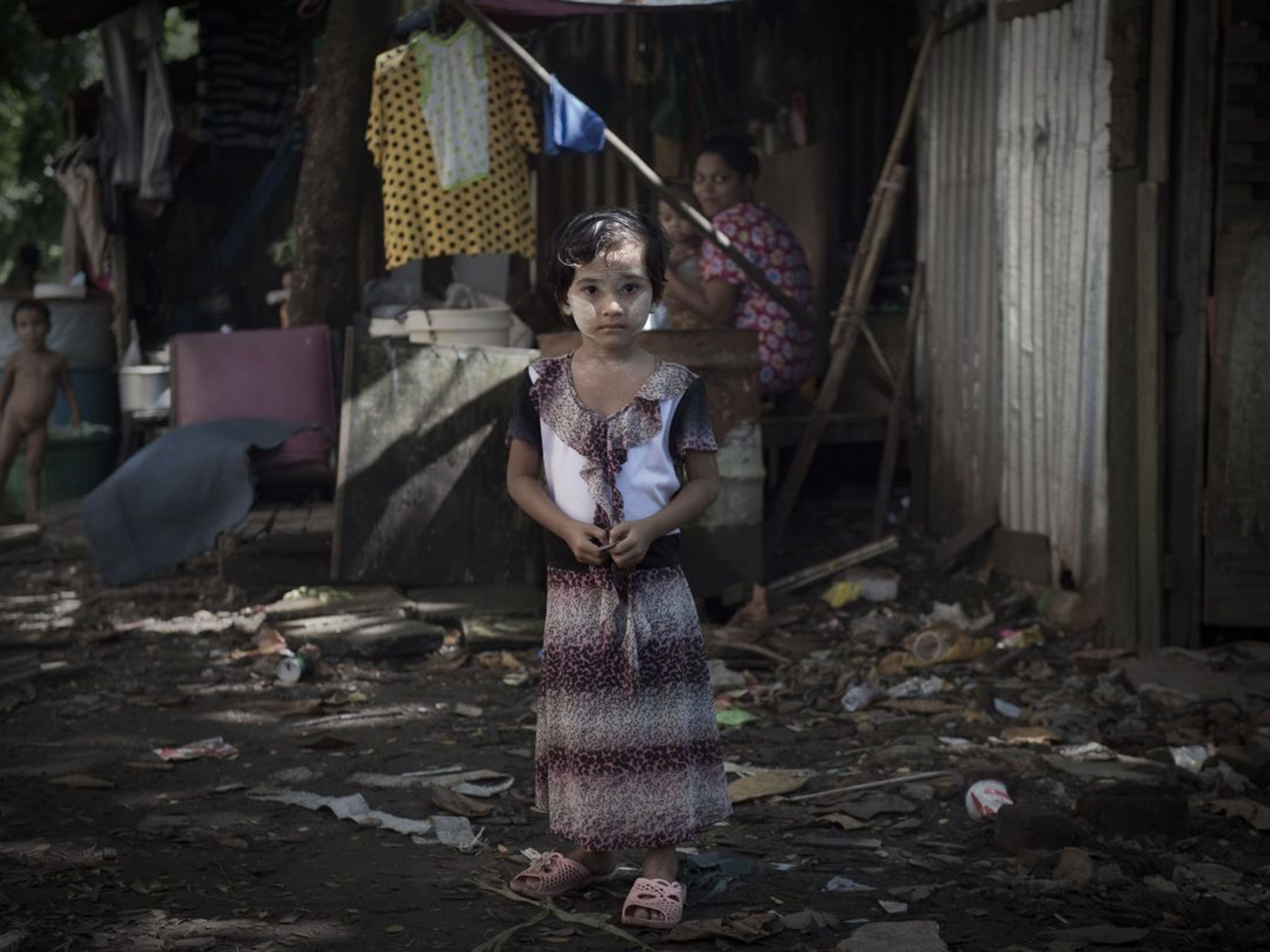 A Burmese girl looks on in a slum in Rangoon on 6 November