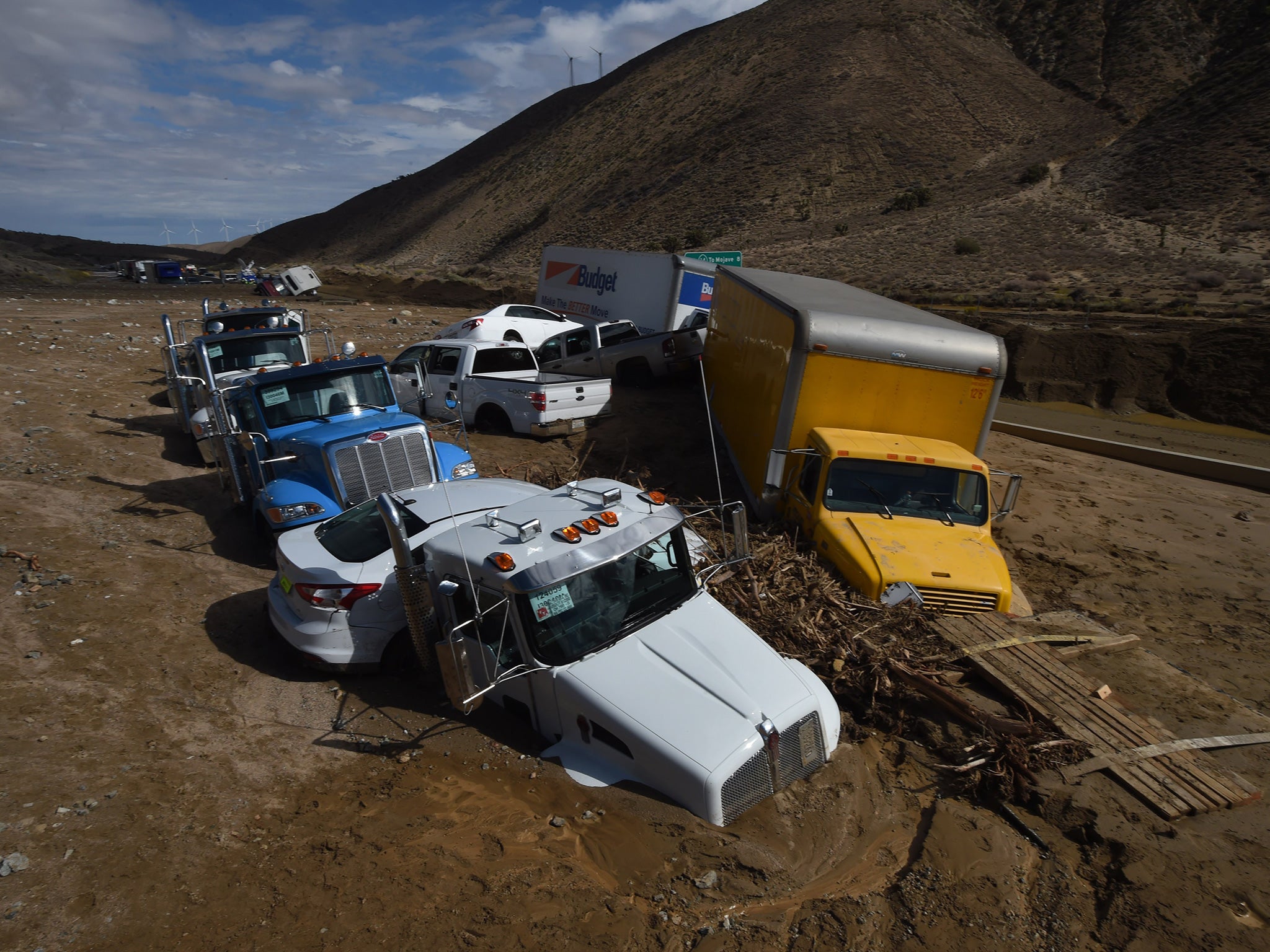 Vehicles are stuck on a road after being trapped by a mudslide on California Highway 58 in Mojave, California on October 16, 2015