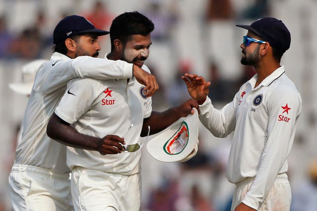 India's Varun Aaron, centre, captain Virat Kohli, right, and Murali Vijay celebrate the wicket of Simon Harmer during the third day of their test against South Africa