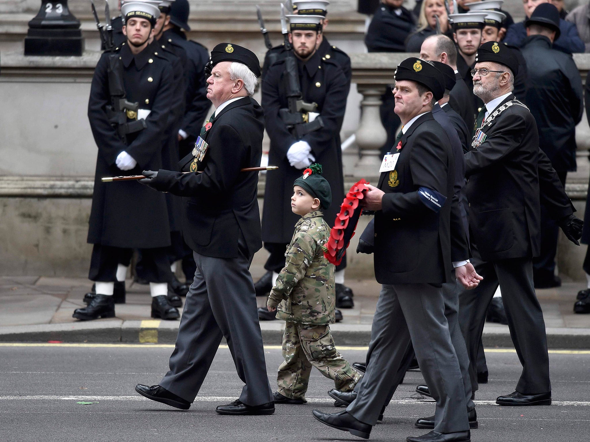 A young boy joins veterans marching in the ceremony Reuters