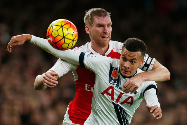 Arsenal defender Per Mertesacker competes with Dele Alli for the ball