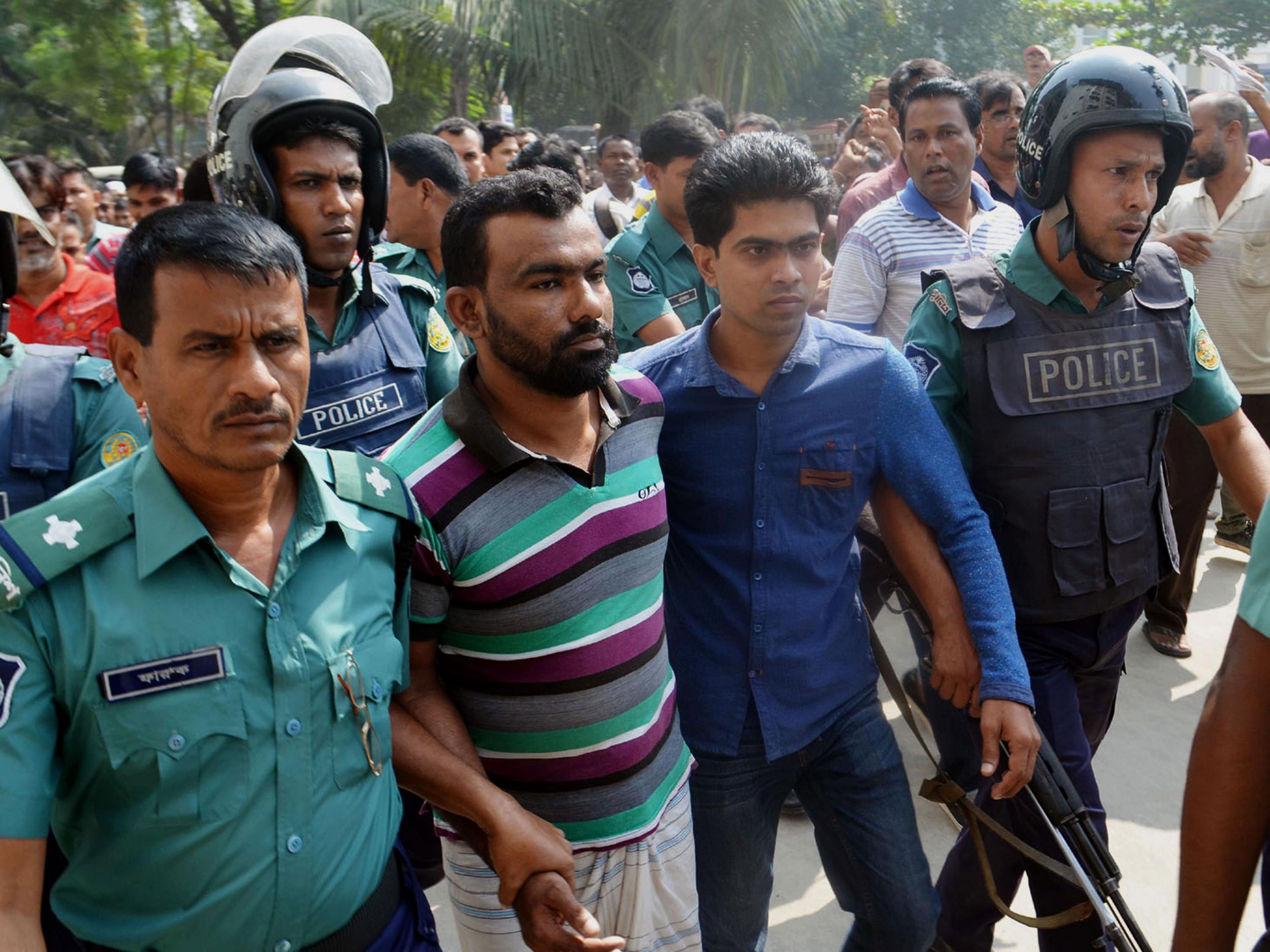 Bangladesh police escort a suspect (C) in a high-profile murder case involving the brutal killing of a child at a court in Khulna