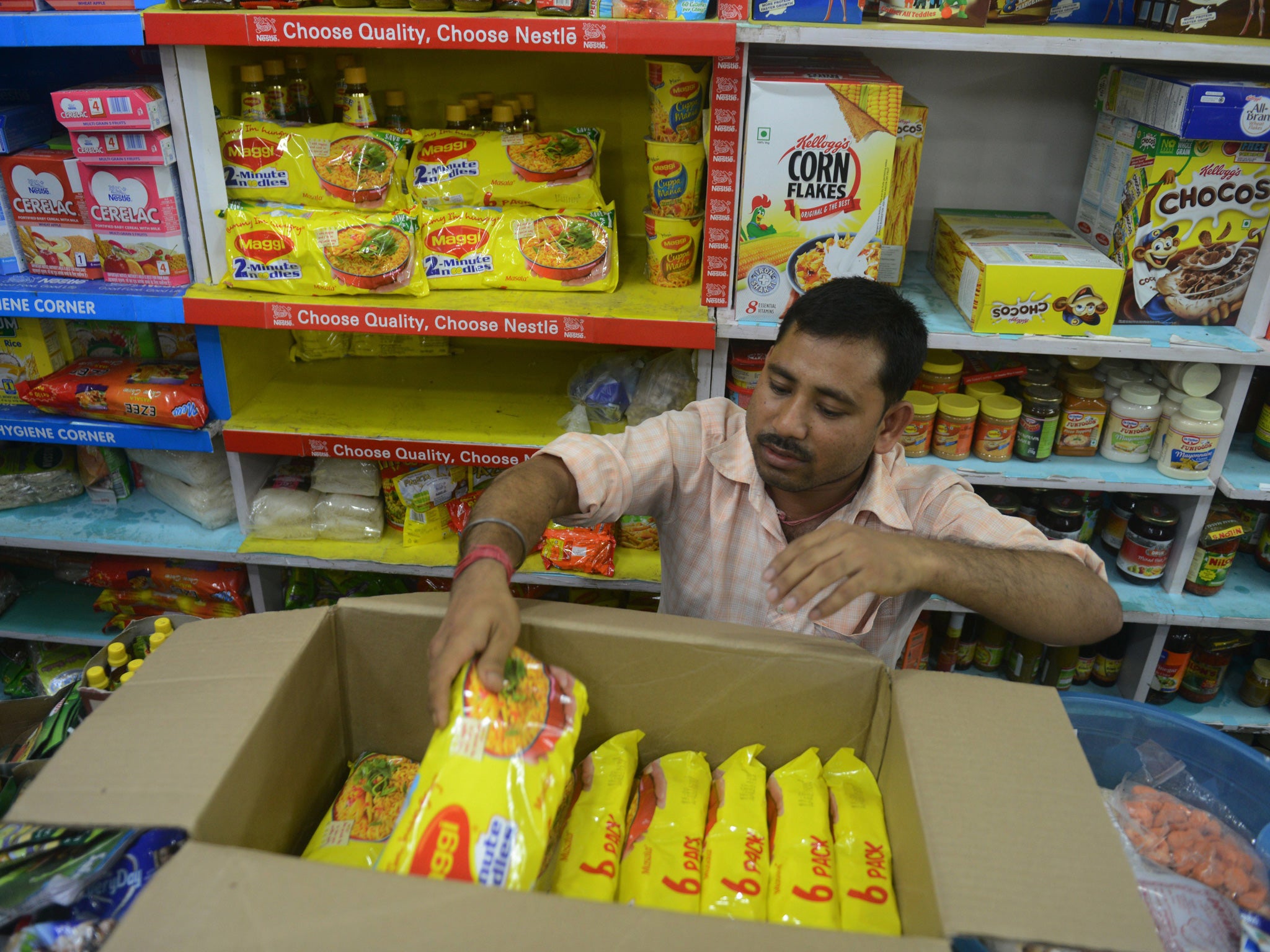 An Indian shopkeeper removes packets of Nestle 'Maggi' instant noodles from the shelves in his shop in Siliguri on June 5, 2015