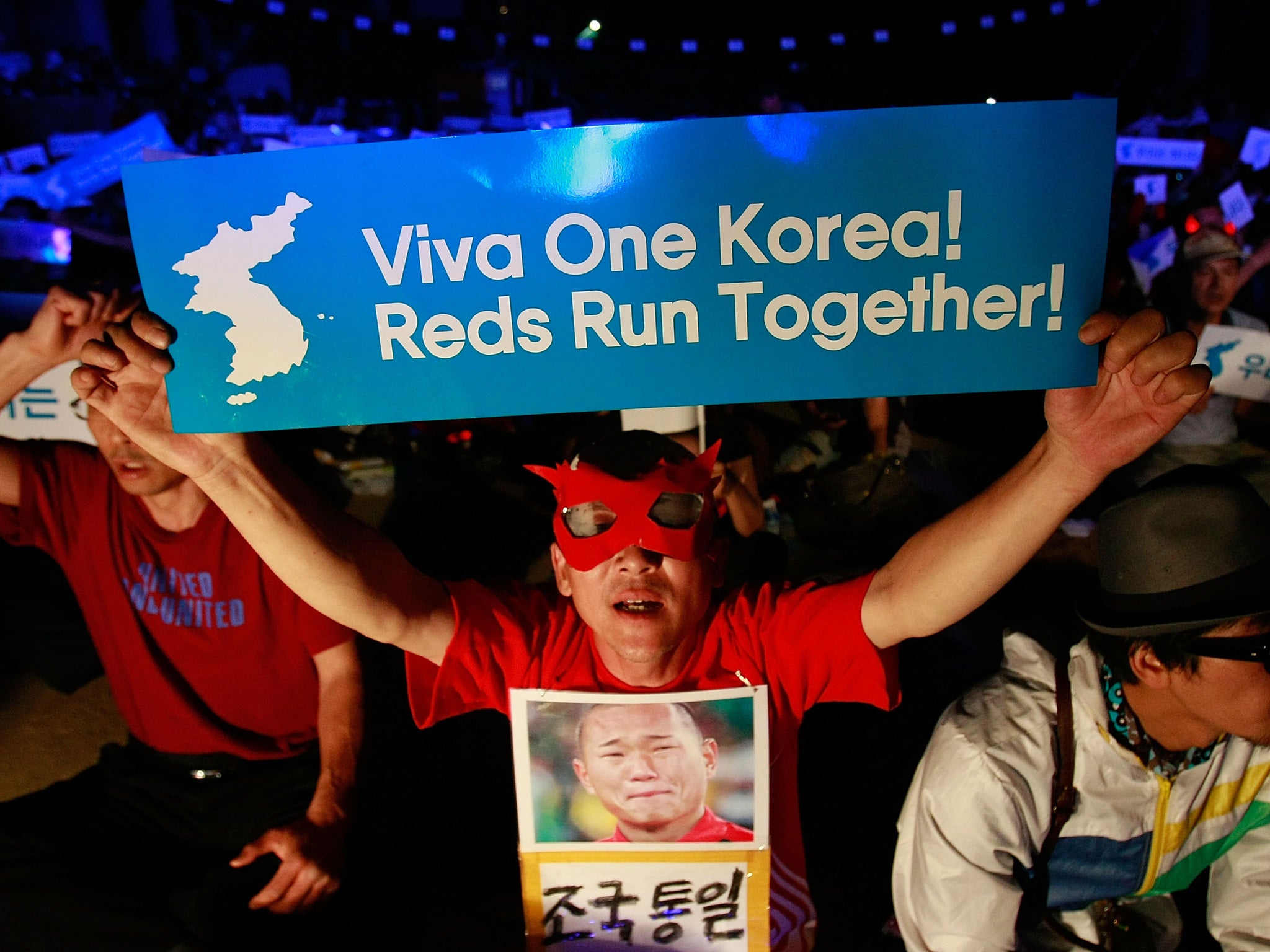 South Koreans wave unification flags as they cheer on the North Korean team in a game at the 2010 football world cup