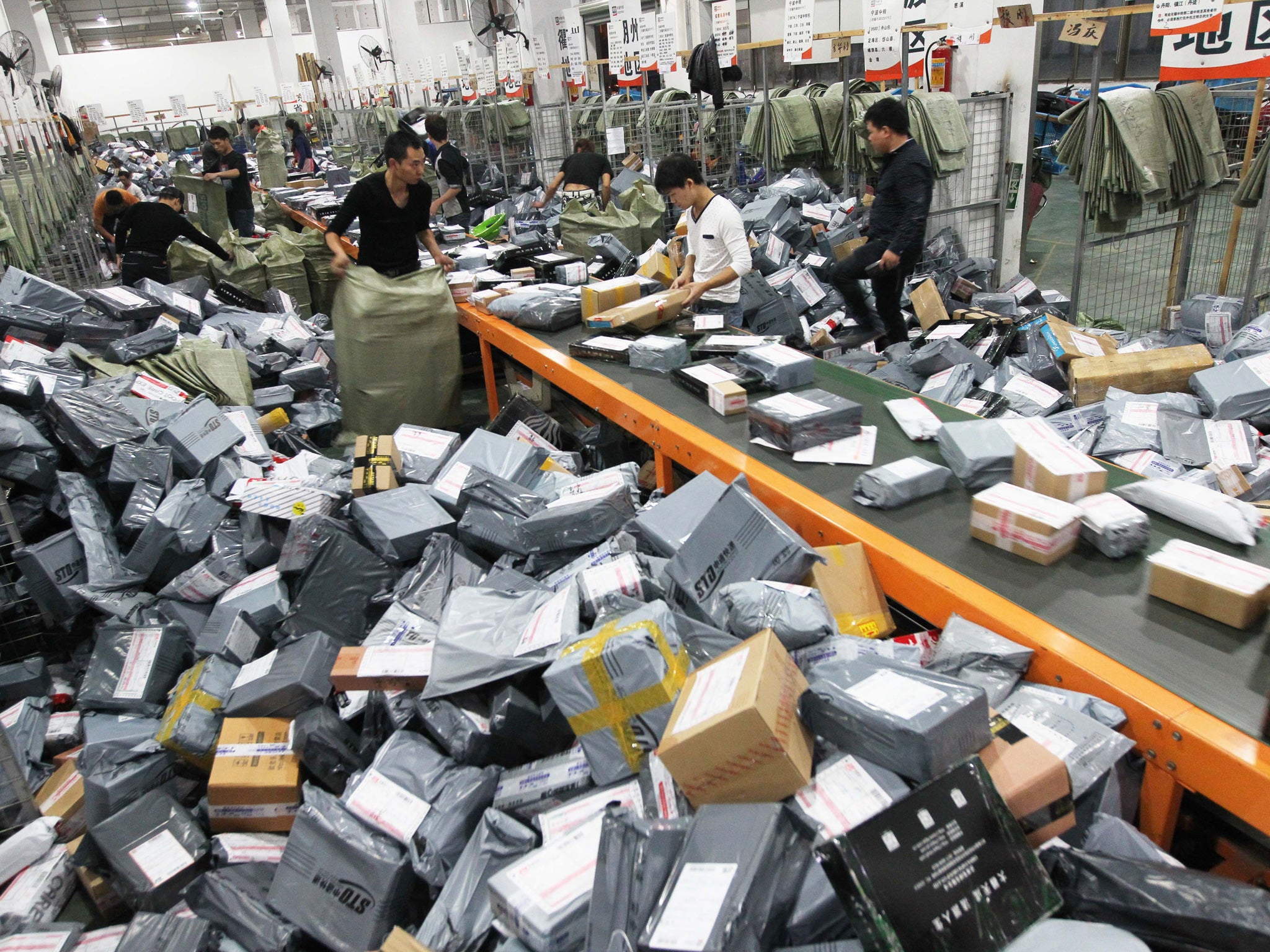 Express crew deal with express packages at assembly line on November 12, 2014 in Wenzhou, Zhejiang province of China. Online shopping websites offered massive discounts on Singles' Day (November 11) every year, which brings huge pressure to China's express delivery business during that day.