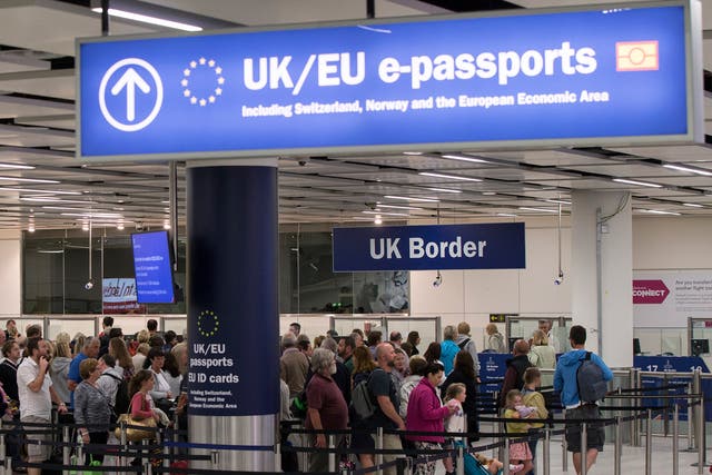 Passengers at Gatwick Airport queue to have their passports checked upon entering the UK