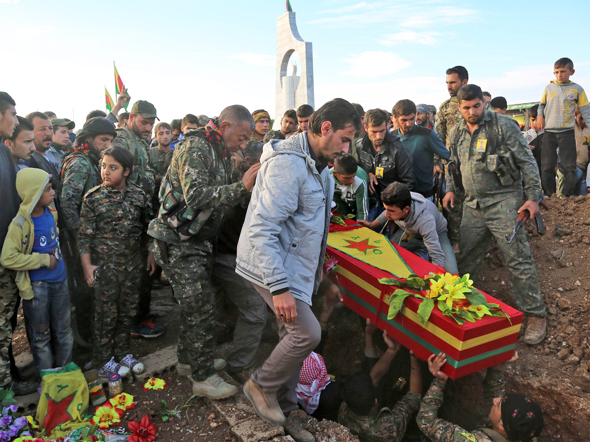 Fighters from the Syrian Democratic Forces bury a comrade on Wednesday. He was killed fighting Isis in the north-eastern Syrian city of al-Hol