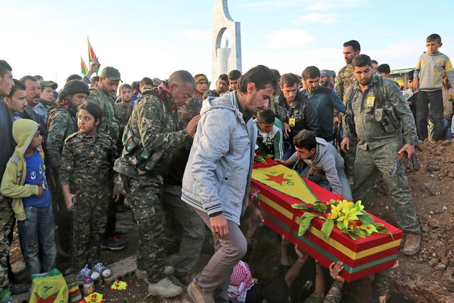 Fighters from the Syrian Democratic Forces bury a comrade on Wednesday. He was killed fighting Isis in the north-eastern Syrian city of al-Hol