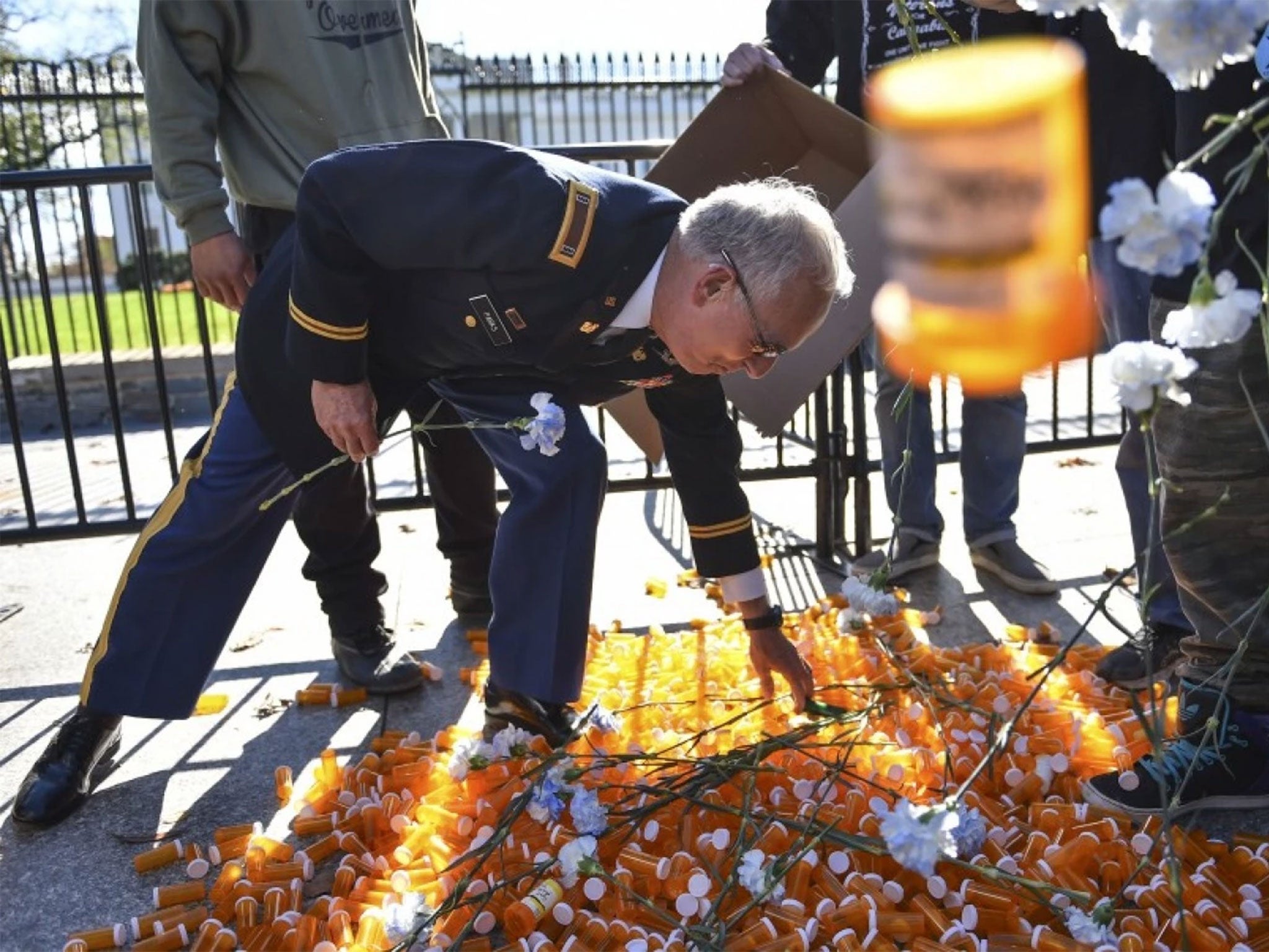 Army veteran Perry Parks reaches to lift a symbolic pill bottle