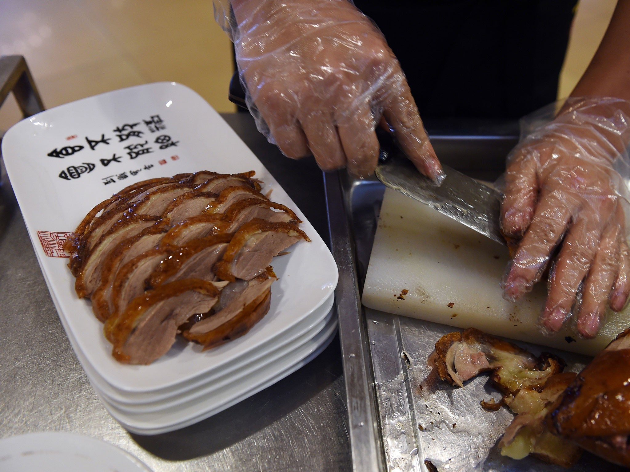 A chef slicing Peking Duck for diners at the Quanjude restaurant in Beijing