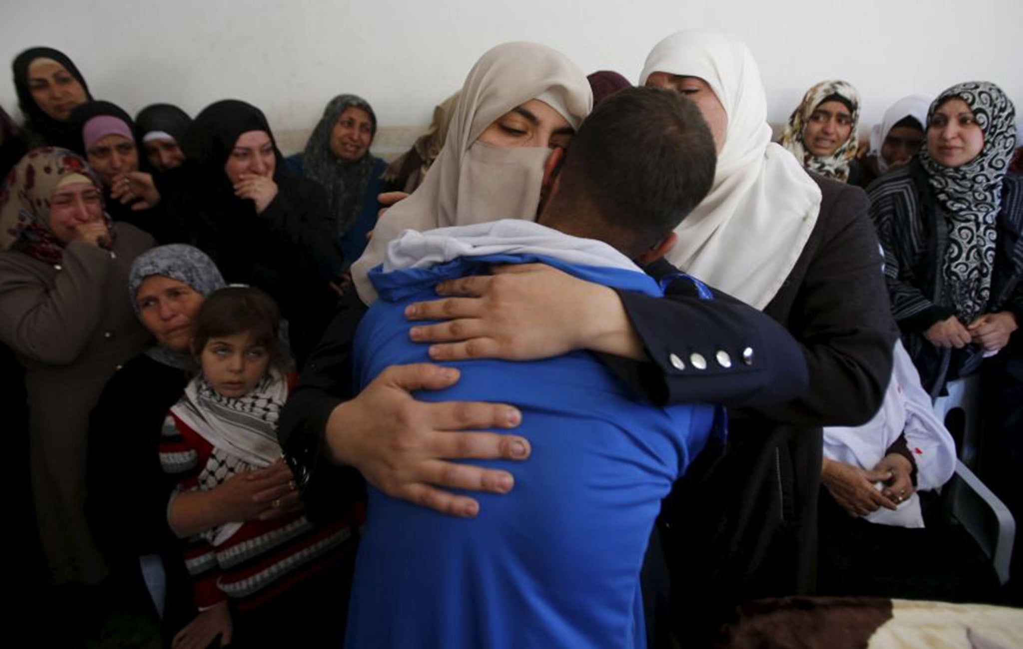 Relatives of Palestinian Abdullah al-Shalalda, who was killed by Israeli undercover forces during a raid at Al-Ahly hospital, mourn during his funeral in the West Bank village of Sair