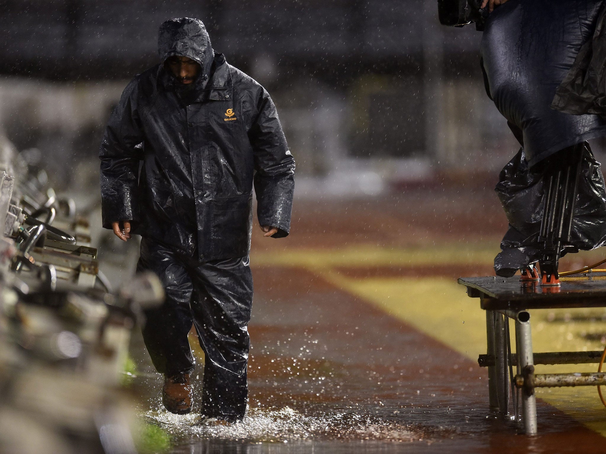 A man walks under heavy rain before the postponed World Cup 2018 qualifying match between Argentina and Brazil