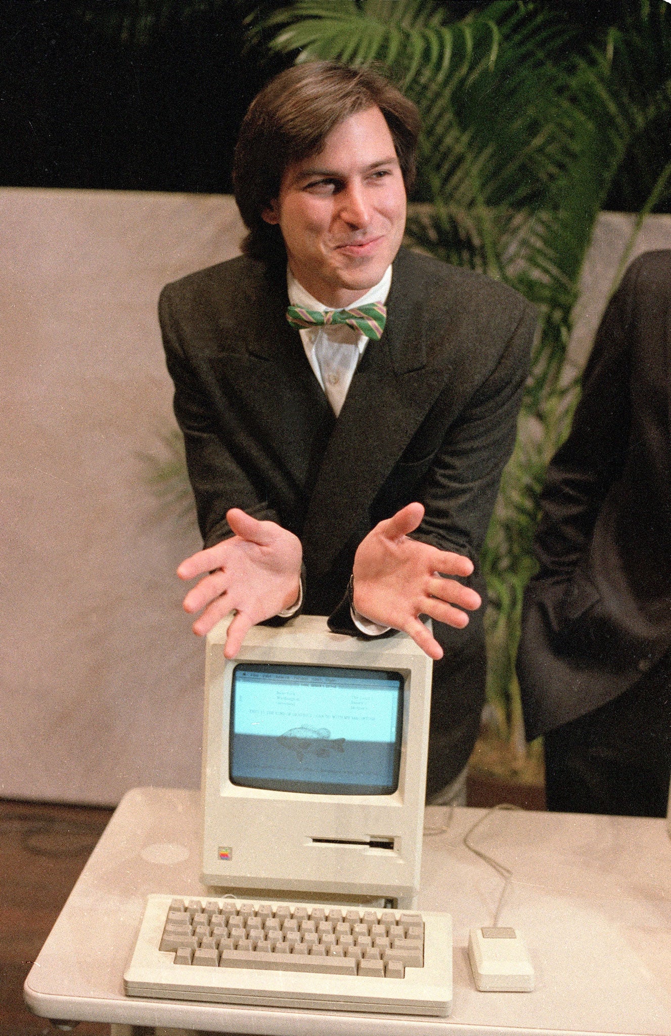Steve Jobs leans on the new Macintosh personal computer in 1984