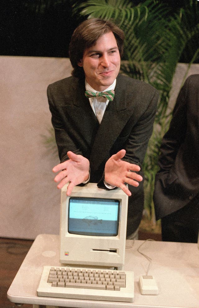 Steve Jobs leans on the new Macintosh personal computer in 1984
