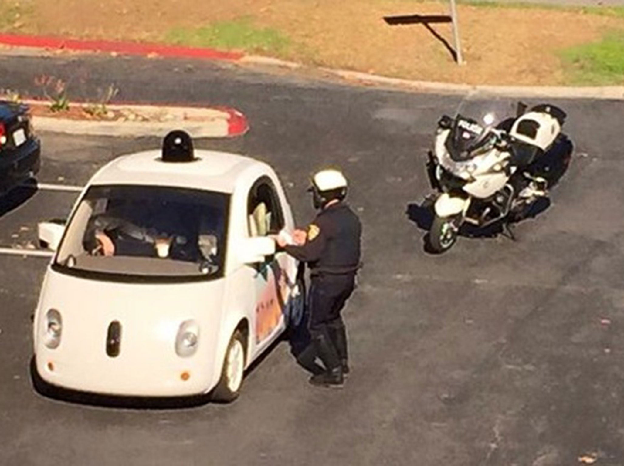A police officer chats to the self-driving cars (human) back-up driver