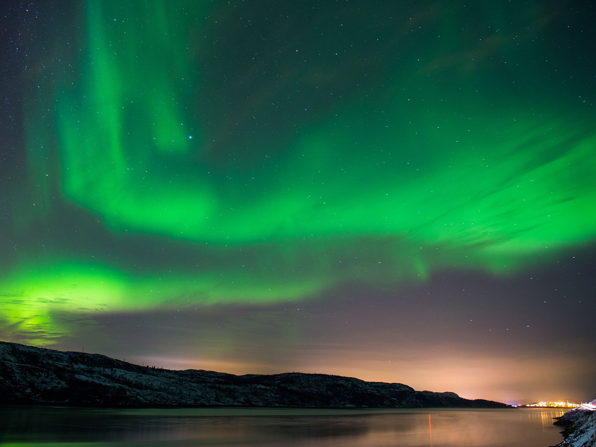 The Aurora Borealis or Northern Lights illuminate the night sky, near the town of Kirkenes in northern Norway